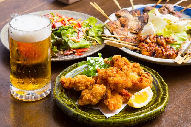 唐揚げやサラダ、ビールが並ぶ宴会のテーブル